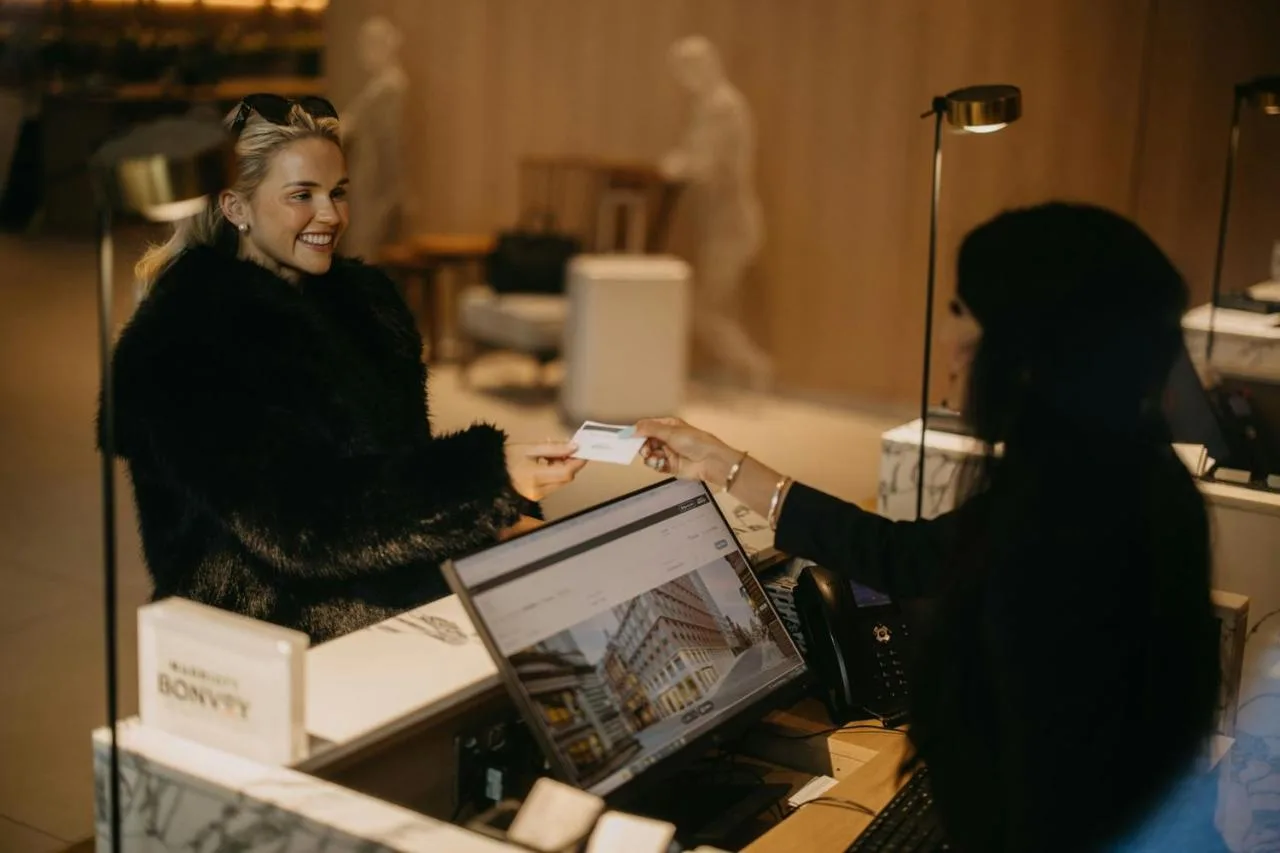 Front desk staff assisting a guest at AC Hotel Glasgow
