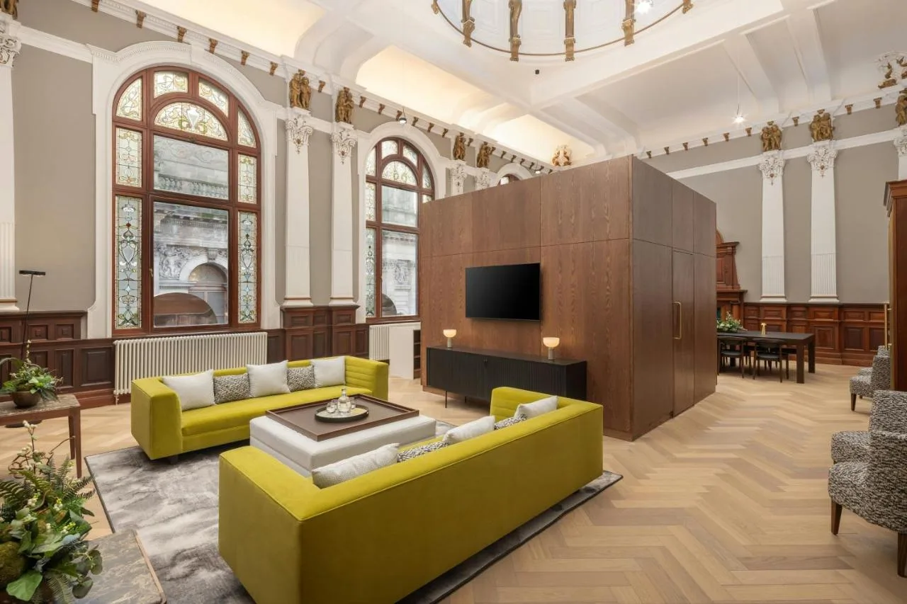 Yellow couches and TV in a guest lounge at AC Hotel Glasgow